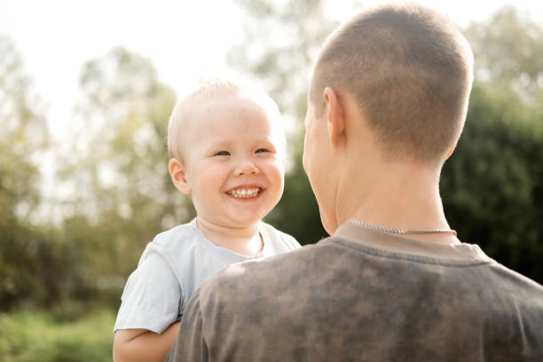 A little boy is having fun in the park with his older brother