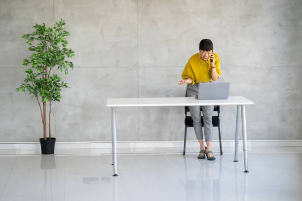 istock Woman on phone, multitasking at desk in a modern and stylish office space 2177550128