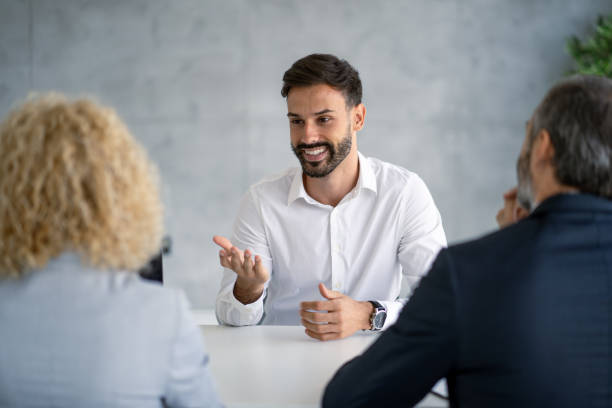 istock Young man enthusiastically shares ideas at a meeting table discussion. 2177550166