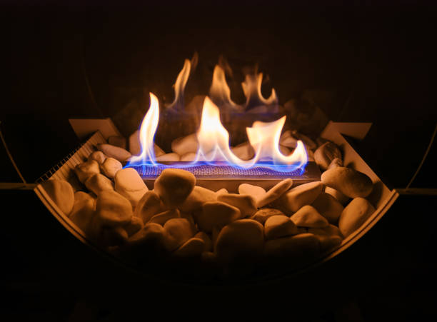 istock Flame in a decorative fireplace with white stones and glass panels 2177551468