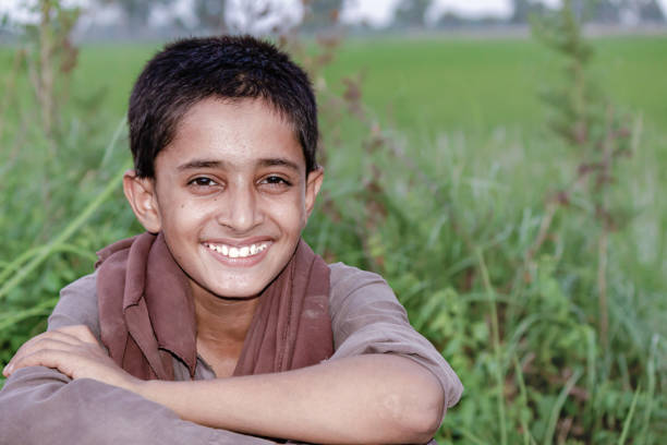 Joyful Indian Boy Smiling in a Lush Countryside Field