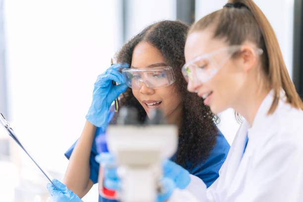 istock Two female scientists work in a laboratory with blood samples and test tubes filled with solution with pipettes from droppers while conducting research. 2177556252