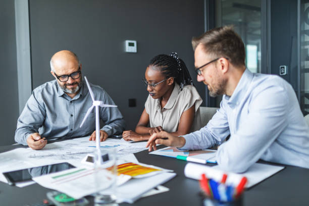 istock Colleagues discussing construction drawings on sustainable energy resources: windmills 2177556570