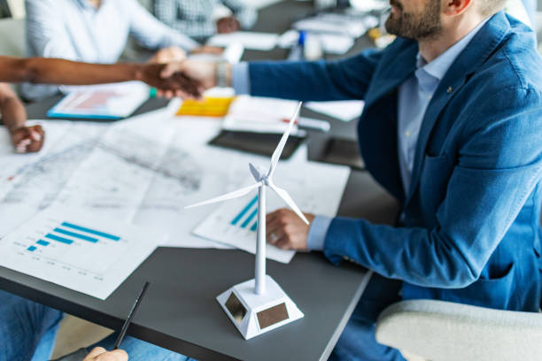 istock Colleagues discussing construction drawings on sustainable energy resources: windmills 2177556871