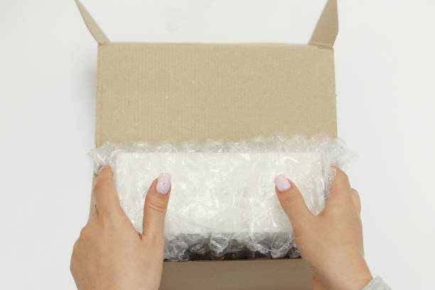 istock Womans hands packing with bubble wrapped for protection parcel product and putting in a brown cardboard parcel box.unpacking parcel 2177559207