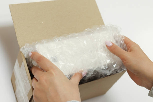 istock Womans hands packing with bubble wrapped for protection parcel product and putting in a brown cardboard parcel box.unpacking parcel 2177559473