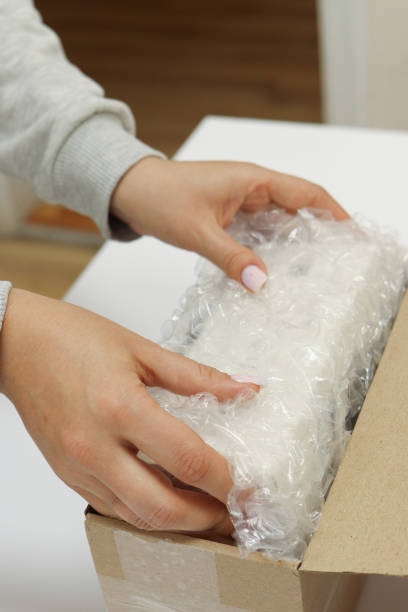 istock Womans hands packing with bubble wrapped for protection parcel product and putting in a brown cardboard parcel box.unpacking parcel 2177559547