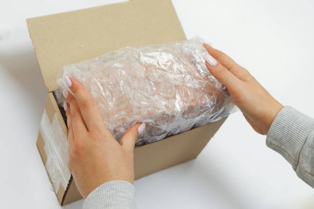 istock Womans hands packing with bubble wrapped for protection parcel product and putting in a brown cardboard parcel box.unpacking parcel 2177559809
