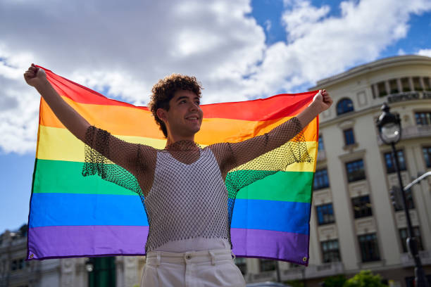 istock A man holding a rainbow flag in front of a building 2177560821