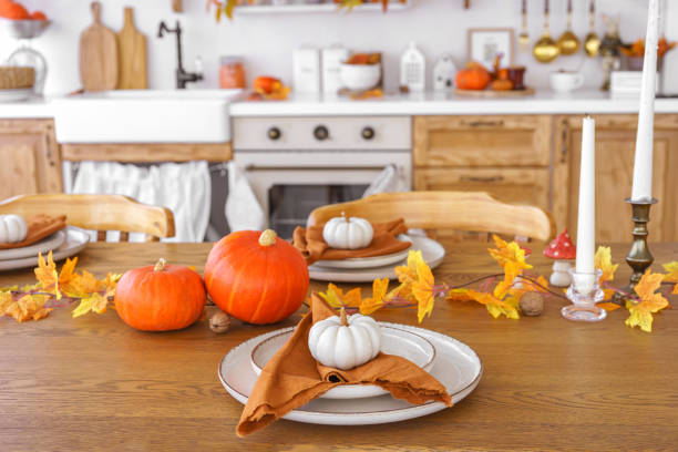istock Dining table decorated with pumpkins and fall foliage in a cozy kitchen setting for autumn holiday 2177561030