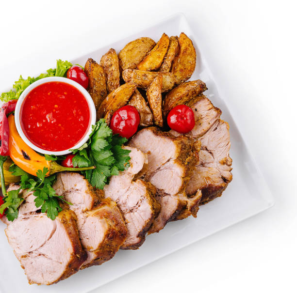 Succulent roasted pork dish served with potatoes, pickles, and a tangy sauce
