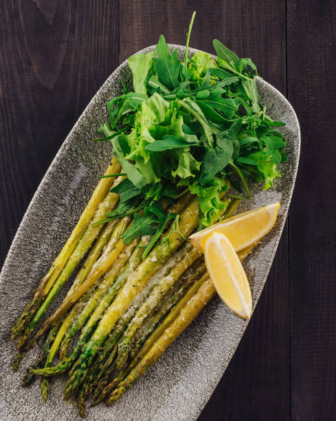 istock Roasted asparagus with lemon and arugula salad on a plate 2177565954