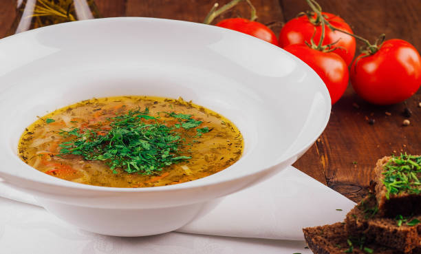 istock Chicken soup with herbs being served with bread and tomatoes 2177566259
