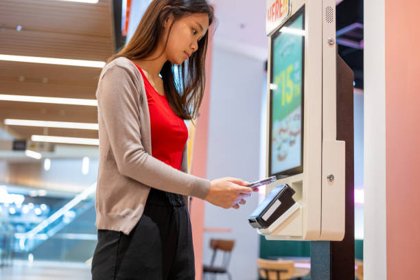 istock A young Asian woman at making a mobile payment at self-service kiosk 2177568902