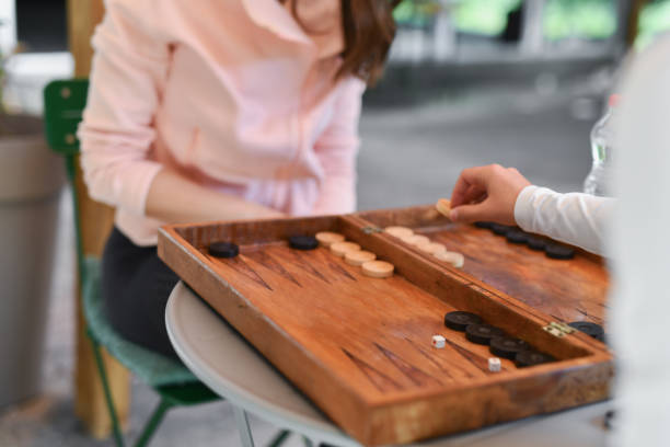 istock Female Player Moving Figures in Backgammon Against Friend 2177573613