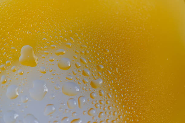 Water droplets on glass with yellow background