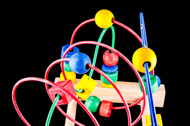A colorful toy with a wooden base and a blue handle. The toy is a puzzle with many different colored balls