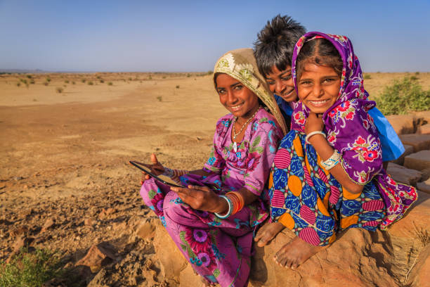 istock Happy Indian children using digital tablet, desert village, India 2177578631