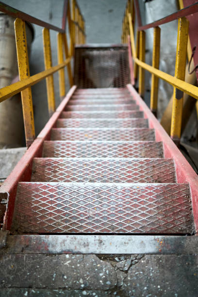 istock Example of chemical plant steampunk retro style interior part with copyspace. Abstract image of industrial textured rusted stairs going down vertical or downstairs. 2177581365