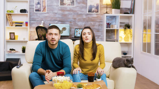 istock Couple sitting on the couch cheering up 2177582213
