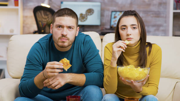 istock Scared couple while watching tv and eating junk food 2177582946