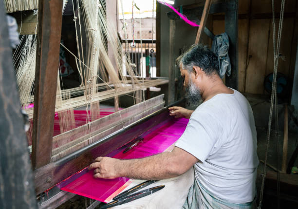 A traditional wooden loom used for crafting vibrant red fabrics in a Moroccan workshop, showcasing handweaving craftsmanship.