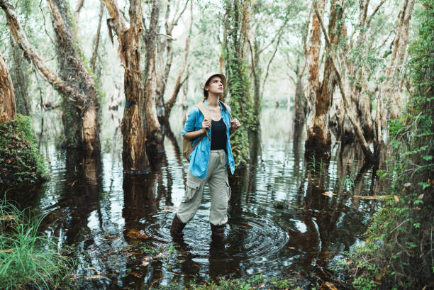 Female botanist looking around in the rainforest with positive emotions.