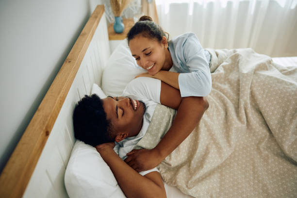 istock Young happy couple talking while relaxing in bedroom. 2177584619