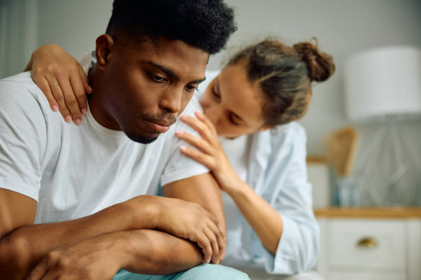 istock Sad black man being consoled by his girlfriend in bedroom. 2177584658