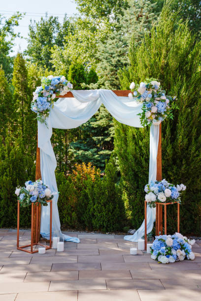 A wedding arch for the ceremony decorated with white and blue flowers