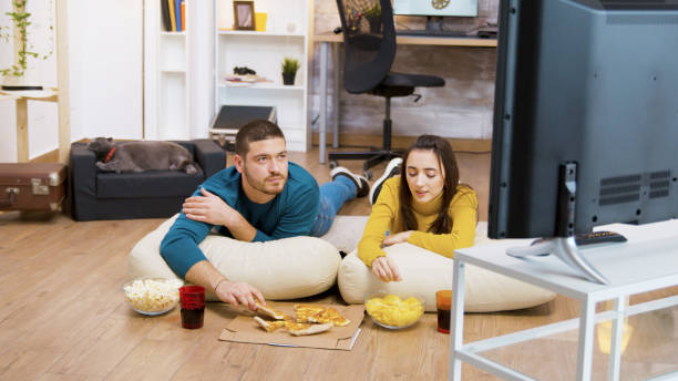 istock Bearded man drinking soda and sitting on pillows for the floor 2177585541