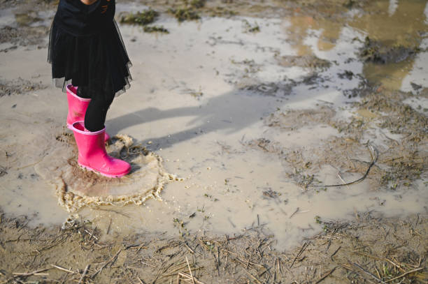 istock Little girl walking in a big puddle 2177586661