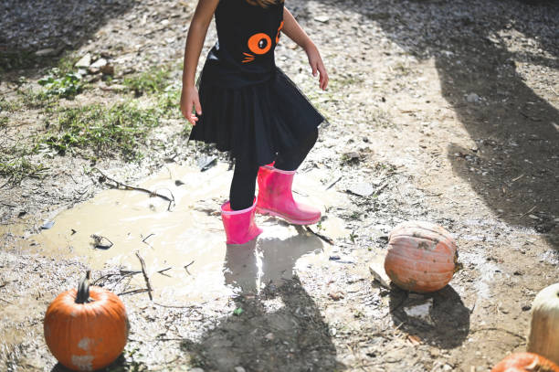istock Little girl  jumping in a big puddle 2177586729