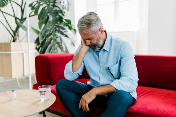 istock Senior man feeling unwell, suffering from backache, massaging aching muscles while sitting on sofa in the living room at home. Elderly and health issues concept 2177588704