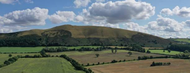 Caer Caradoc hill and fields around with cumulus clouds above
