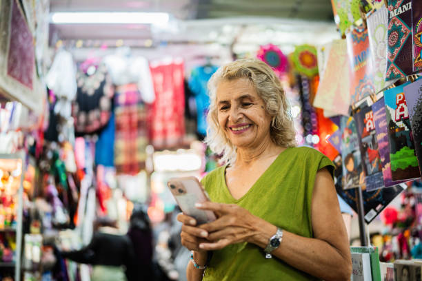 istock Senior woman using mobile phone at market 2177602872