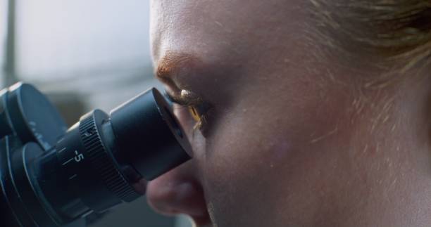 istock Female biochemist looks under microscope, does analysis of sample. Macro Close Up 2177606894