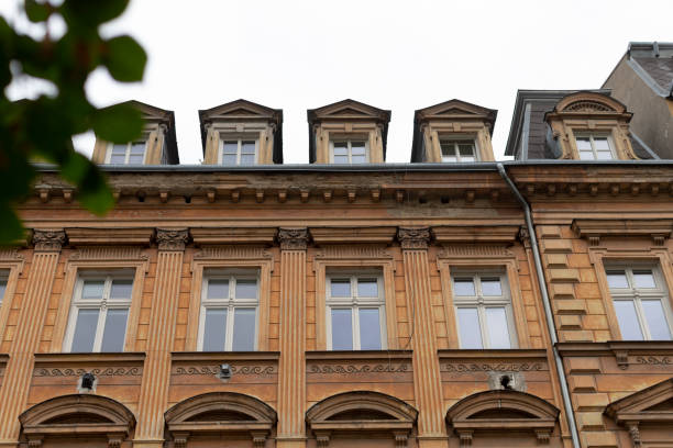 istock A tall building with numerous windows and a large tree in the foreground 2177607986