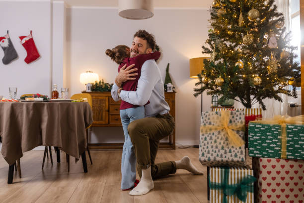 istock Father and daughter share a warm embrace by the Christmas tree 2177608731