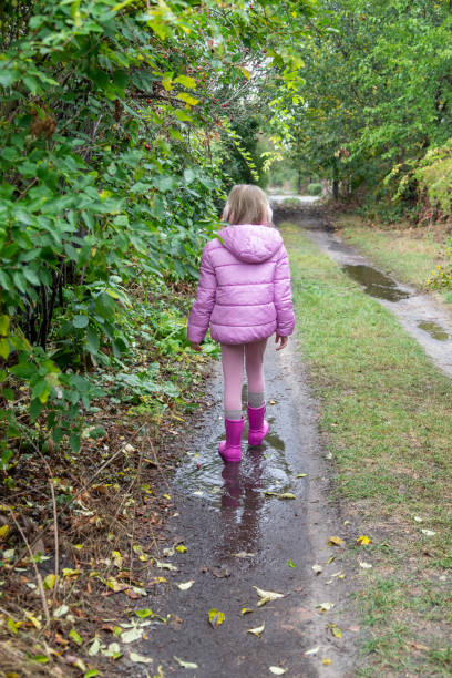 istock a girl runs through puddles during the rain 2177613784