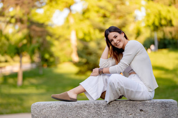 istock Woman relaxing on bench in the park 2177619051