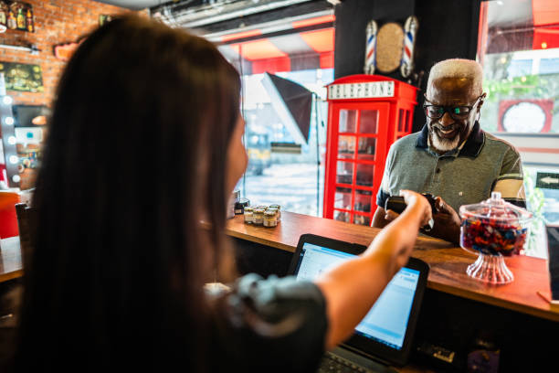istock Senior man paying with mobile phone at a barber shop 2177619285