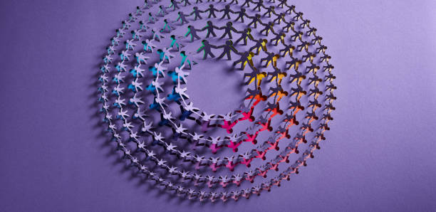 istock Circular Paper Chain of Human Figures with Rainbow Gradient on Purple Background 2177619350