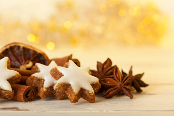 Closeup of Cinnamon Star Shortbread cookies with spices, golden bokeh
