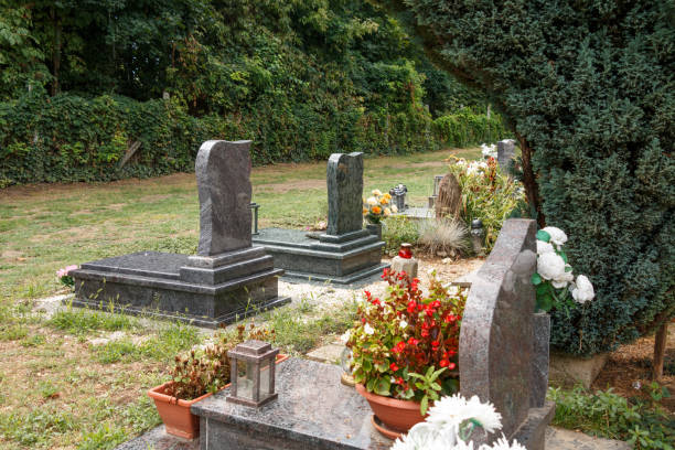 istock graves with flowers and lanterns in a green cemetery 2177621953