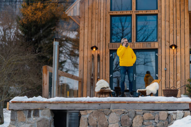 istock Man working from cozy cabin in mountains, making call with client. Concept of remote work from beautiful, peaceful location. Hygge at work. 2177622119