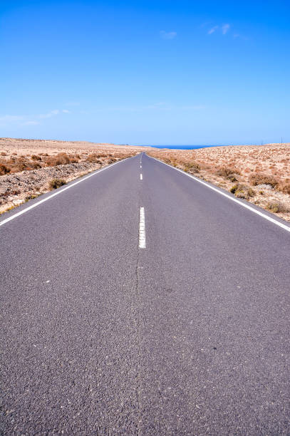 istock A long, empty road with a blue sky in the background 2177623237