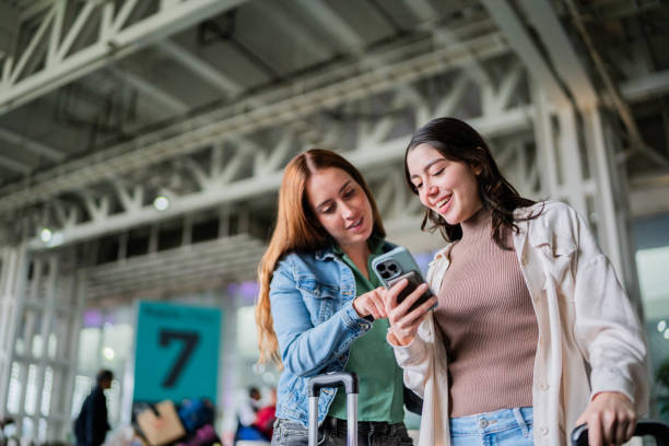 istock Friends women talking and using mobile phone at airport 2177626896