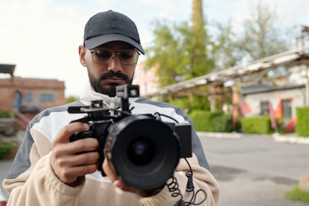 istock Photographer Adjusting Camera Settings Outdoors 2177630963