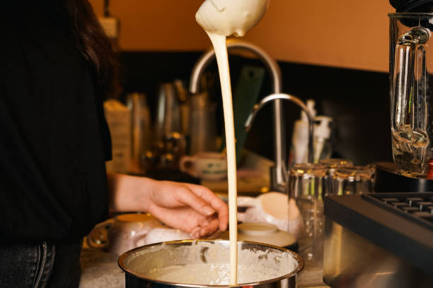 istock Liquid dough poured waffle iron machine to prepare Belgian waffle. Cooking process. Food preparation. Making Belgian waffles. Female hand pours dough into waffle maker in kitchen at home. Breakfast. 2177634307
